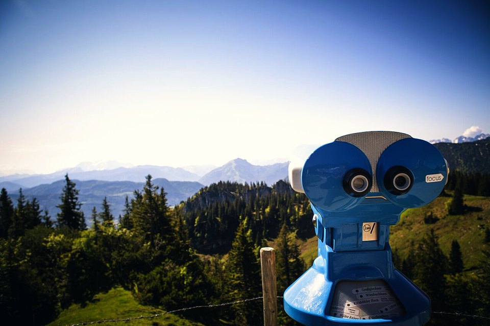 Viewing scope against blue sky and mountains: classic, no AI